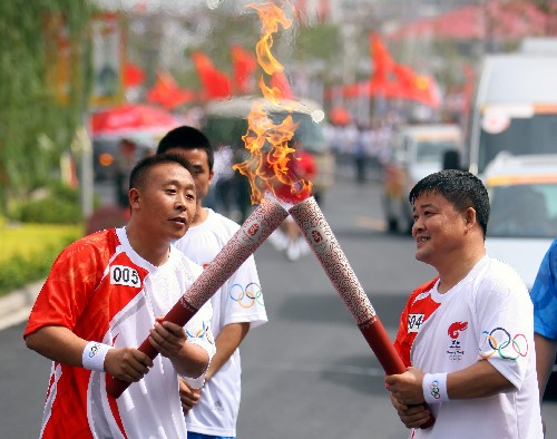 5月30日,奧運(yùn)火炬手姚民和(右)與程曉明在傳遞過(guò)程中交接。當(dāng)日,北京奧運(yùn)圣火在安徽績(jī)溪傳遞。 新華社記者邢廣利攝