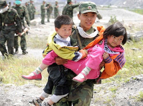 5月16日,在四川汶川縣映秀鎮(zhèn),一名解放軍戰(zhàn)士往直升機上送兩名兒童轉(zhuǎn)移。 今年的“六一”兒童節(jié)是一個特殊的節(jié)日,它是汶川大地震后迎來的第一個節(jié)日。在這場舉世震驚的災(zāi)難中,災(zāi)區(qū)部分幼兒園毀了、學(xué)校垮塌了,許多如花的生命逝去,許多劫后余生的孩子失去了父母、失去了親人。在地震中,他們表現(xiàn)得異常堅強,他們懂得面對、懂得感恩、懂得回報、懂得剛毅堅韌、懂得樂觀從容……我們不會忘記那個被救出時要冰凍可樂的“可樂男孩”、那個躺在擔(dān)架上舉起一只稚嫩的小手的“敬禮娃娃”、瓦礫中女孩勇敢的微笑、還有在“帳篷學(xué)校”里高唱國歌的孩子……現(xiàn)在他們還帶著傷痛,他們的精神創(chuàng)傷和心靈的恐懼需要我們?nèi)嵛?、他們需要我們綿綿不絕的幫助和關(guān)愛。在這個特殊的兒童節(jié)來臨之際,讓我們?yōu)闉?zāi)區(qū)兒童送上溫馨的祝福! 親愛的孩子們!你們一定要堅強,擦干眼淚,愛將與你們同行。 新華社記者 陳樹根 攝