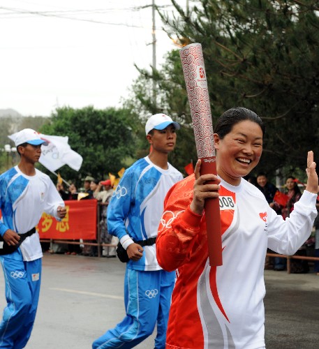 6月21日,火炬手曉紅手持火炬?zhèn)鬟f。當(dāng)日,北京奧運會圣火傳遞活動在西藏拉薩舉行。 新華社記者覺果攝