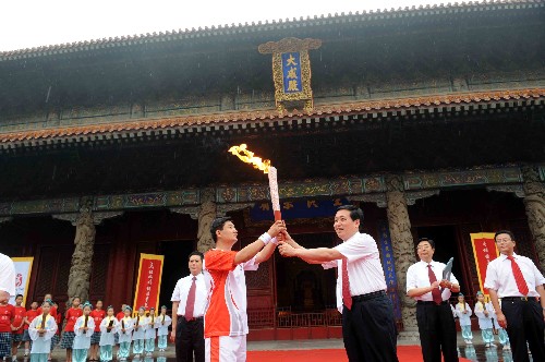 奧運(yùn)圣火在曲阜傳遞 7月22日,第一棒火炬手孔鵬(前左)在大成殿前接過(guò)火炬。當(dāng)日,北京奧運(yùn)圣火在山東省曲阜市傳遞。 新華社記者范長(zhǎng)國(guó)攝