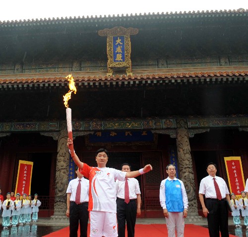 奧運(yùn)圣火在曲阜傳遞 7月22日,第一棒火炬手孔鵬在大成殿前舉起火炬。當(dāng)日,北京奧運(yùn)圣火在山東省曲阜市傳遞。 新華社記者范長(zhǎng)國(guó)攝