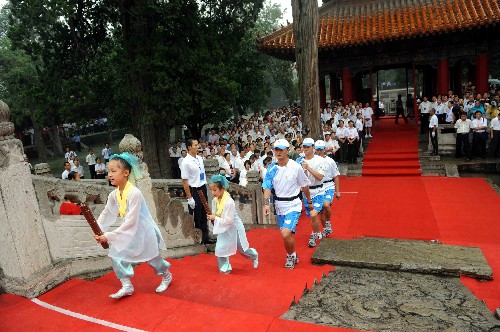 7月22日,圣火禮儀護(hù)衛(wèi)人員手持火種燈在書(shū)童的引領(lǐng)下來(lái)到大成殿。當(dāng)日,北京奧運(yùn)圣火在山東省曲阜市傳遞。 新華社記者范長(zhǎng)國(guó)攝