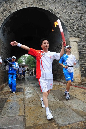 7月22日,火炬手李挺手持火炬?zhèn)鬟f。當(dāng)日,北京奧運(yùn)圣火在山東省曲阜市傳遞。 新華社記者劉力航攝