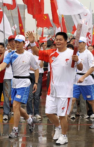 7月22日,最后一棒火炬手宮治華手持火炬?zhèn)鬟f。當(dāng)日,北京奧運圣火在山東省曲阜市傳遞。 新華社記者朱崢攝