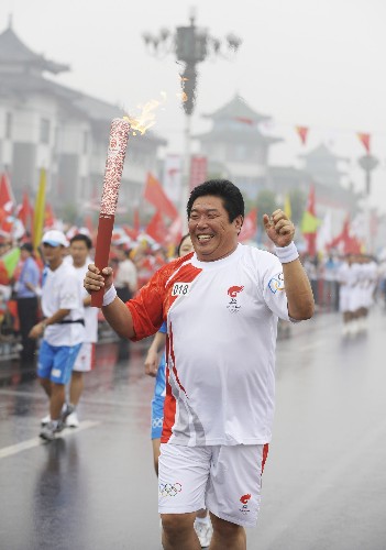 7月22日,火炬手謝瑛琪手持火炬?zhèn)鬟f。當(dāng)日,北京奧運圣火在山東省曲阜市傳遞。 新華社記者戚恒攝