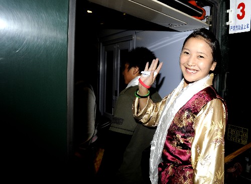 西藏奧運志愿者啟程赴京 8月1日,一名志愿者在拉薩火車站向送別的人群告別。當(dāng)日,來自西藏自治區(qū)的80名北京奧運會志愿者乘坐火車從拉薩出發(fā),他們將為參加北京奧運會的各國運動員、記者等提供志愿服務(wù)。 新華社記者普布扎西攝