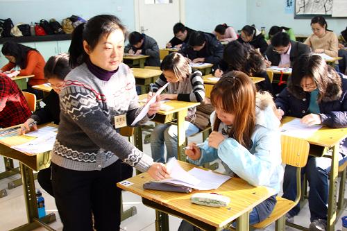 11月30日,北京一中學(xué)考場的監(jiān)考人員在發(fā)試卷。新華社記者 高學(xué)余 攝