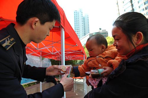 3月15日,一名抱小孩的市民在學(xué)習(xí)如何辨別假冒偽劣食品。當(dāng)日,貴陽(yáng)市云巖區(qū)質(zhì)檢局走上街頭,在貴陽(yáng)市云巖廣場(chǎng)為廣大消費(fèi)者講解如何辨別假冒偽劣產(chǎn)品,并向消費(fèi)者宣傳消費(fèi)者權(quán)益保護(hù)知識(shí)。 新華社發(fā)(劉續(xù)攝)