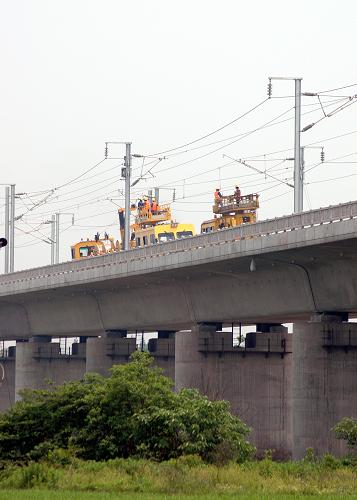 5月8日,在武(漢)廣(州)客運專線新長沙站到新汨羅站區(qū)段的撈刀河特大橋上,中鐵電氣化局西安電化公司的職工正在架設電氣化網(wǎng)線。新華社發(fā)(倪樹斌 攝)