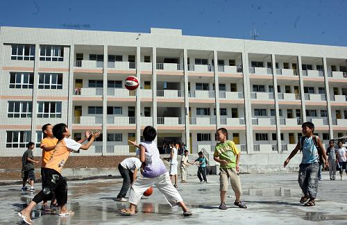 8月30日,四川省華鎣市明月小學的學生在新落成的教學大樓前玩籃球。新華社發(fā)(邱海鷹 攝)