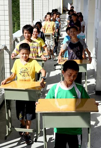 8月30日,四川省華鎣市明月小學的學生在新落成的教學大樓搬運新課桌。新華社發(fā)(邱海鷹 攝)