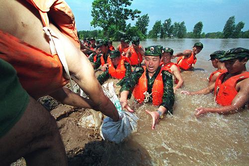 1998年夏,全國上下眾志成城,軍民干群團結(jié)一心,在中華大地譜寫了一出威武雄壯的抗洪壯歌。 這是解放軍濟南軍區(qū)某部官兵跳入洪水中在荊江大堤險段搶險(資料照片)。 新華社發(fā)