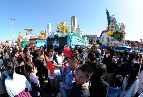 10月3日,游客在天安門廣場(chǎng)的彩車前拍照留影。 當(dāng)日,天安門廣場(chǎng)游人如潮,來自全國各地的游客紛紛到北京天安門廣場(chǎng)觀光游覽,拍照留念,歡度國慶長假。 新華社記者 楊宗友 攝