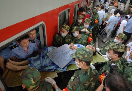 5月19日,鐵路職工和民兵將傷員從車廂內(nèi)送到站臺,統(tǒng)一抬上救護車。當(dāng)日17時許,按照鐵道部統(tǒng)一部署,成都鐵路局開行的首趟運送地震災(zāi)區(qū)受傷群眾專列順利抵達重慶龍頭寺火車站。208名在此次地震中受傷的群眾,被200多輛救護車迅速轉(zhuǎn)運到重慶市內(nèi)的各大醫(yī)院接受治療。新華社記者 劉潺 攝