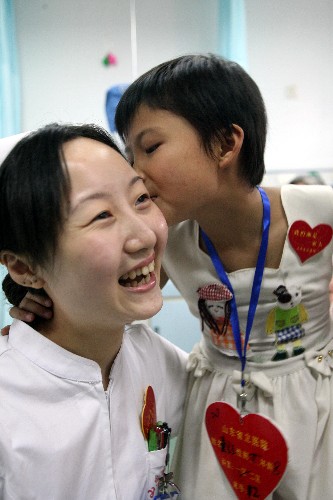 6月11日,在山東省立醫(yī)院援川愛(ài)心病房,即將出院的小傷員董金玉吻謝醫(yī)護(hù)人員。新華社發(fā)(呂傳泉 攝)