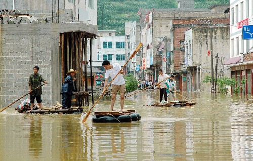 6月12日,在廣西凌云縣邏樓鎮(zhèn),群眾劃著竹筏在被水淹沒的街道中穿行。新華社記者 向志強 攝