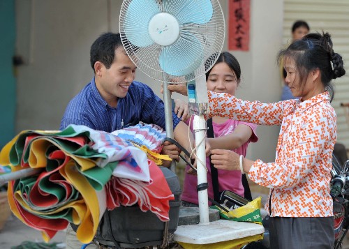 6月14日,廣西藤縣一戶居民在搬運物品,準備轉(zhuǎn)移。新華社記者 周華 攝