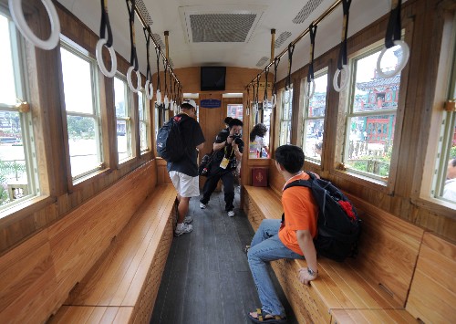 7月31日,幾名記者在北京前門大街的“鐺鐺車”上拍攝。新華社記者 羅曉光 攝