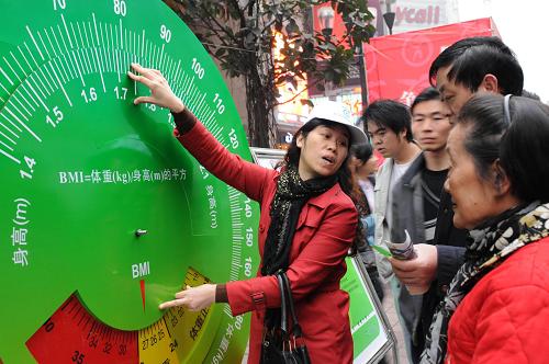 2月15日,志愿者在全民健康生活方式行動(dòng)現(xiàn)場(chǎng)指導(dǎo)市民使用體檢指數(shù)計(jì)算尺。新華社發(fā)(鐘桂林 攝)