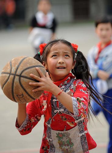3月18日,河口城區(qū)小學的一名女學生在課后玩籃球。新華社記者 藺以光 攝