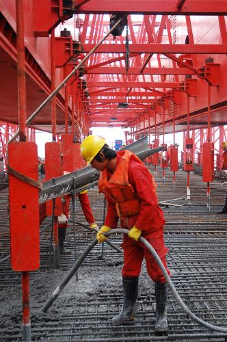 3月21日,施工人員在向莆鐵路東新贛江特大橋工地澆筑首片50米1500噸箱梁。新華社發(fā)(胡國林 攝)