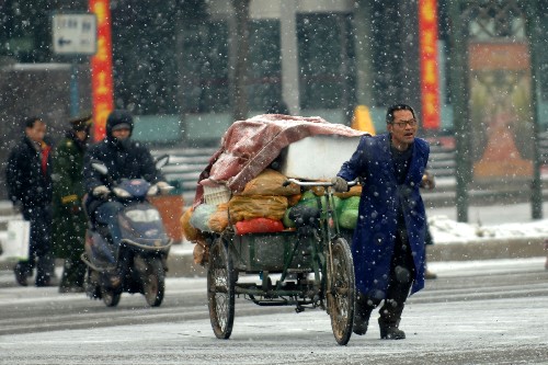 1月25日,西安市民冒雪前行。 陜西省連續(xù)兩日的好天氣還未使積雪消融,24日晚上又迎來(lái)今年以來(lái)第三次強(qiáng)降溫降雪天氣過(guò)程。自1月11日以來(lái),陜西省出現(xiàn)的持續(xù)降雪,是自1957年以來(lái)最強(qiáng)降雪過(guò)程。 新華社記者 丁海濤 攝