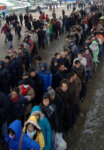 1月25日,旅客在西安火車站冒雪排隊(duì)購(gòu)票。新華社記者 丁海濤 攝