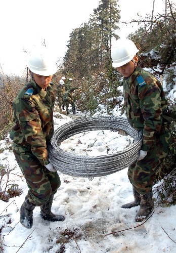 2月14日,兩名戰(zhàn)士在搬運(yùn)供電材料。為確保井岡山早日通電,駐贛空軍某部千名官兵連日來(lái)奮戰(zhàn)在崇山峻嶺之中。 新華社發(fā) (朱文標(biāo) 攝)
