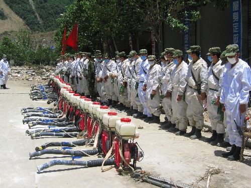 7月5日,防化兵在北川縣城內(nèi)待命,準(zhǔn)備噴灑消毒液。新華社記者 劉思揚(yáng) 攝