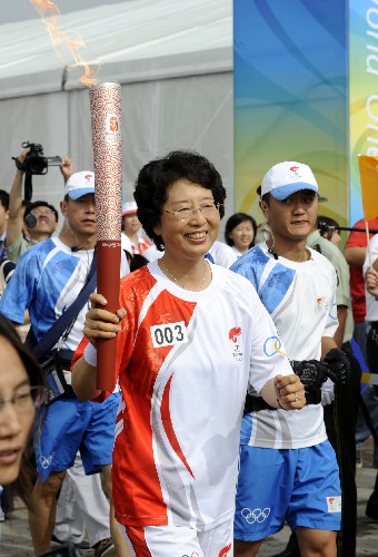 7月21日,火炬手臧愛(ài)民手持火炬進(jìn)行傳遞。當(dāng)日,北京奧運(yùn)圣火在山東省青島市傳遞。 新華社記者李紫恒攝