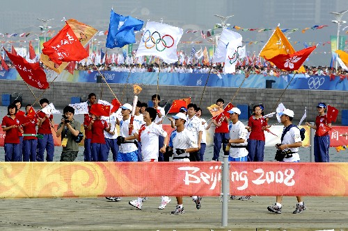 7月21日,火炬手臧愛(ài)民手持火炬進(jìn)行傳遞。當(dāng)日,北京奧運(yùn)圣火在山東省青島市傳遞。 新華社記者李紫恒攝