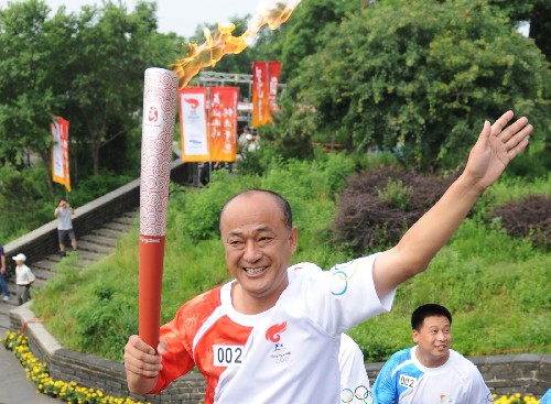 7月30日,火炬手聶瑞平手持火炬進(jìn)行傳遞。當(dāng)日,北京奧運(yùn)圣火在河北省秦皇島市傳遞。 新華社記者楊世堯攝