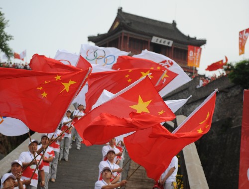 7月30日,人們在火炬?zhèn)鬟f起點(diǎn)揮舞旗幟迎接圣火。當(dāng)日,北京奧運(yùn)圣火在河北省秦皇島市傳遞。 新華社記者楊世堯攝