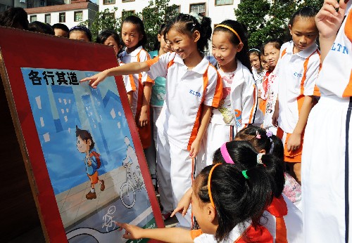 9月1日,南漳縣實驗小學學生們在校園里觀看交通安全展覽。 當日,湖北省南漳縣公安局交警大隊的交警來到南漳縣實驗小學,給學生們講解交通安全知識和法規(guī),作為新學期開學的第一堂課。 新華社發(fā)(熊明銀 攝)