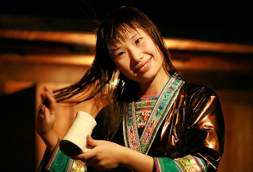 9月23日,在廣西融水苗族自治縣桿洞鄉(xiāng)黨鳩苗寨,一位苗族姑娘用電吹風(fēng)吹干頭發(fā)。新華社發(fā)(龍濤 攝)