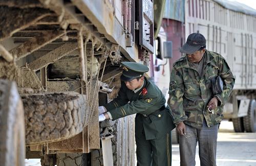內(nèi)蒙古甘其毛都口岸邊防檢查站的邊檢人員在認(rèn)真檢查出入境大型貨車,避免出現(xiàn)走私現(xiàn)象(10月14日攝)。新華社記者 李欣 攝