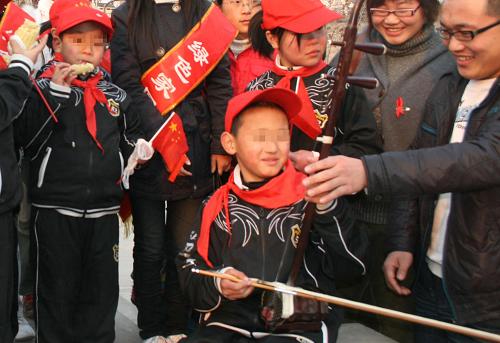 11月30日,一名大學(xué)生志愿者教一名艾滋病患兒拉二胡。當(dāng)日,山西省臨汾市紅絲帶小學(xué)的12名艾滋病患兒在老師帶領(lǐng)下,走進(jìn)山西師范大學(xué)校園,感受大學(xué)生的豐富生活,與大學(xué)生志愿者進(jìn)行交流。新華社發(fā)(王輝耀 攝)