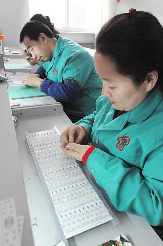 2月10日,智障殘疾人在沈陽(yáng)市“陽(yáng)光工場(chǎng)”里加工電子插件。新華社發(fā)(楊新躍 攝)