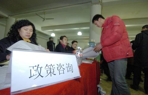 2月10日,求職者(前右)在招聘會(huì)現(xiàn)場(chǎng)設(shè)置的政策咨詢處翻閱材料。新華社記者 邵守志 攝
