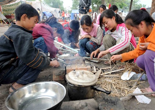 5月17日,南壩鎮(zhèn)中學(xué)學(xué)生在生火燒水。 新華社記者 任軍川 攝