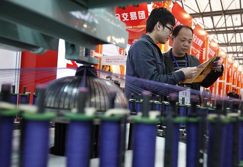 3月1日,一位專業(yè)觀眾(右)正向一家生產(chǎn)服裝提花機(jī)械的展商咨詢業(yè)務(wù)。新華社記者 裴鑫 攝