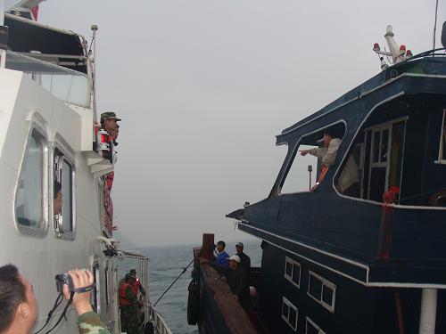 3月21日,福建海警官兵與附近作業(yè)的漁船協(xié)調(diào),救助一艘觸礁遇險(xiǎn)的漁船。 當(dāng)天清晨,一艘福建詔安籍漁船在福建東山龍嶼附近海域觸礁遇險(xiǎn),福建海警第三支隊(duì)二大隊(duì)海警35091艇緊急出警,在東海第二救助飛行隊(duì)及當(dāng)?shù)囟嗨覞O船的配合下,成功將該船拖離礁石區(qū),船上7名漁民順利脫險(xiǎn)。新華社發(fā)(黃志民 攝)