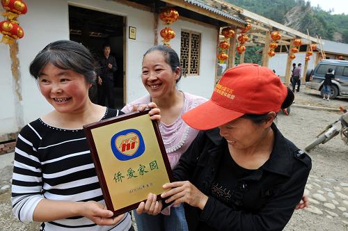 5月11日,關(guān)莊鎮(zhèn)高壩村村民劉紅霞(左一)與新鄰居高興地領(lǐng)到“僑愛家園”的銅牌。當(dāng)日,全國第一家落成的“僑愛家園”在青川縣落成,這個(gè)“僑愛家園”分布在關(guān)莊、竹園兩個(gè)點(diǎn),共160戶,每戶由“僑愛工程—僑愛家園”項(xiàng)目補(bǔ)助建房資金1萬元。汶川大地震發(fā)生后,國務(wù)院僑務(wù)辦公室及時(shí)啟動“僑愛工程—僑愛家園”項(xiàng)目,支持地震災(zāi)區(qū)災(zāi)后重建和社會主義新農(nóng)村建設(shè),支持災(zāi)區(qū)群眾建設(shè)永久性住房。 新華社記者 李紫恒 攝