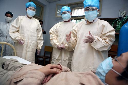 5月11日,在湖北襄樊舉行的一場(chǎng)防控甲型H1N1流感醫(yī)療救治演練中,醫(yī)療組專(zhuān)家對(duì)“患者”進(jìn)行會(huì)診。新華社發(fā)(龔波 攝)