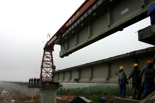 5月11日,由中鐵電化局西鐵工程公司承建的包(頭)西(安)鐵路王子特大橋開始架梁。這標(biāo)志著包西鐵路橋梁施工進(jìn)入新的階段。 包(頭)西(安)鐵路共有特大橋70座,目前已經(jīng)完成全部工程量的70%左右。2007年11月正式開工的包西鐵路北起內(nèi)蒙古自治區(qū)的鐵路樞紐包頭站,經(jīng)鄂爾多斯市、榆林市、延安市至西安鐵路樞紐張橋站,全長(zhǎng)800.9公里,設(shè)計(jì)時(shí)速為160公里,工程投資總額為163億元。 新華社發(fā)(焦宏濤 攝)