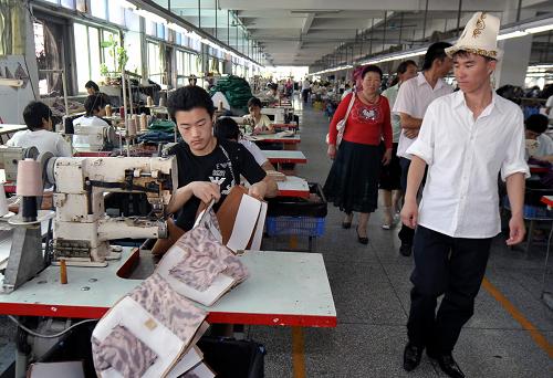 來自新疆阿合奇縣的一位柯爾克孜族小伙在廣東東莞一家企業(yè)參觀(5月14日攝)。新華社記者 趙戈 攝