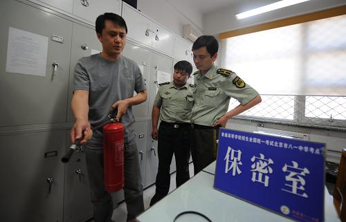 6月3日,消防隊(duì)員對(duì)北京一處高考考點(diǎn)保密室的管理人員(左)進(jìn)行消防知識(shí)檢測(cè)。這里在高考期間將存放高考試卷。當(dāng)天,北京市消防總隊(duì)對(duì)北京高考考點(diǎn)進(jìn)行消防安全檢查。北京市2009年共設(shè)高考考點(diǎn)138個(gè),考場(chǎng)3322個(gè),將有97858名學(xué)生參加高考。 新華社記者 李文 攝