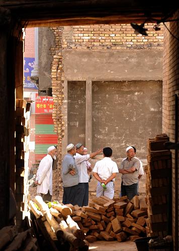 月3日,新疆喀什市老城區(qū)的維吾爾族居民在改造工地上觀看工程進度。 新華社記者 沈橋 攝