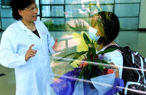 6月5日,醫(yī)務(wù)人員在福州肺科醫(yī)院歡送一名甲型H1N1流感小患者出院。新華社記者 張國(guó)俊 攝