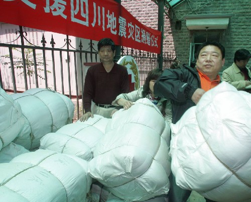 5月13日,天津市民鄭鴻樹(右一)夫婦向?yàn)?zāi)區(qū)捐贈(zèng)總價(jià)值2萬(wàn)元的被子。當(dāng)日,天津各屆群眾通過(guò)不同渠道捐款捐物救助四川地震災(zāi)區(qū)。截至當(dāng)天16時(shí),天津紅十字會(huì)收到捐款捐物總價(jià)值1300萬(wàn)元人民幣。 新華社發(fā)(段毅剛 攝)